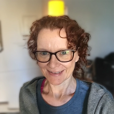 Lizzie Ambrose smiling, she has short curly hair.